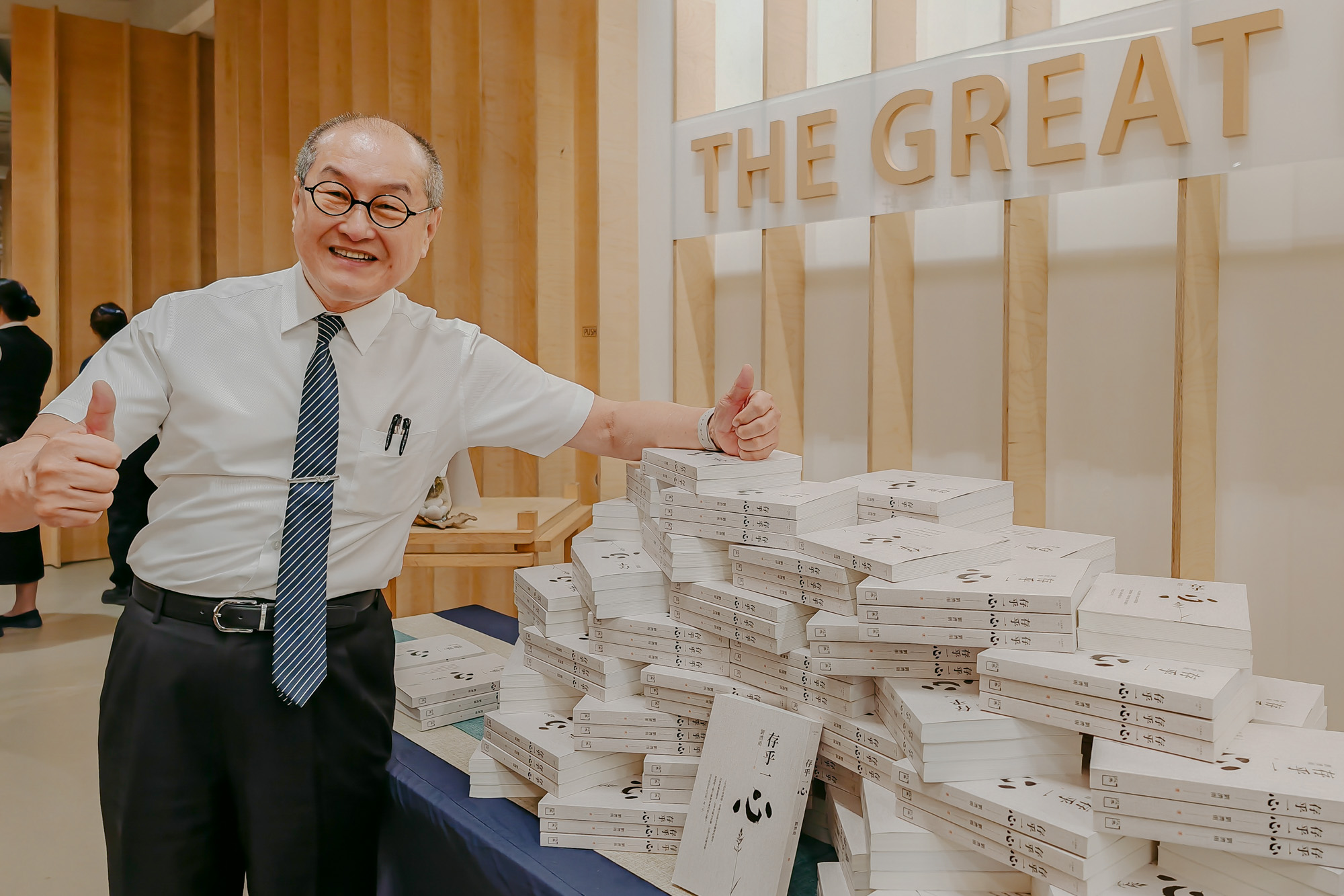 刘济雨赠送书本给每一位出席新书发表会的观众，与他们结一份善缘。观众可扫码自由乐捐。摄/ 王绥喜